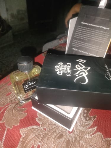 Customer's Sultan perfume bottle and black product box on patterned surface