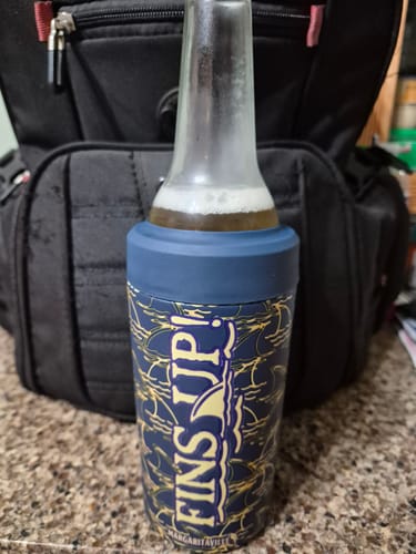 Customer's navy Fins Up Margaritaville Universal Buddy holding a cold beer bottle in front of a black backpack.
