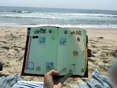 Customer's Beach Birds Variety Sticker Pack used to decorate a bullet journal page while sitting on a sandy beach.