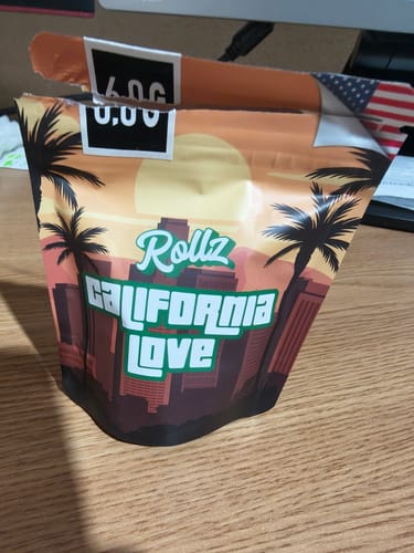 Customer's California Love THCA Flower packaging, featuring a sunset illustration with palm trees on a table.