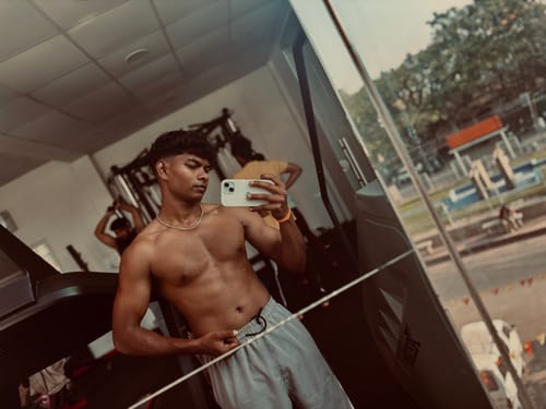 Customer's mirror selfie at a gym, showing physical progress after using Wellcore Creatine Monohydrate.