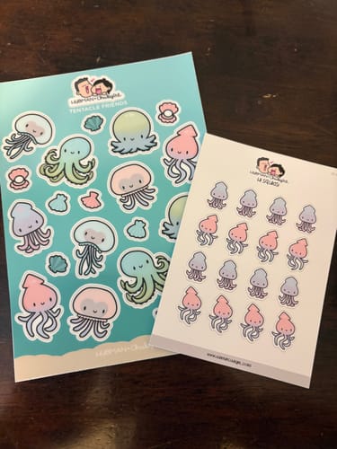 Customer's Mystery Box contents, including two sheets of cute stickers featuring octopus and jellyfish characters.