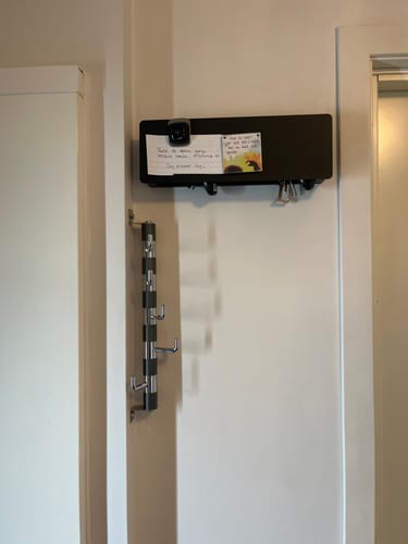Customer's sort Bred nøkkelholder montert på vegg, med en lapp festet til den magnetiske fronten.