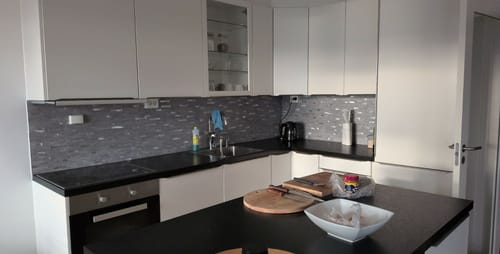 Reviewer's kjøkken med monterte Stein lys grå selvklebende veggfliser over benkeplaten.