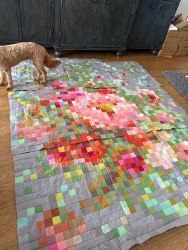 Customer's Tilda Embroidery Flower Precut Quilt Kit layout spread on floor, featuring a floral pixelated design.