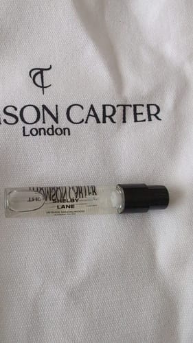 Customer's Shelby Lane eau de parfum sample vial placed on a white branded fabric pouch.