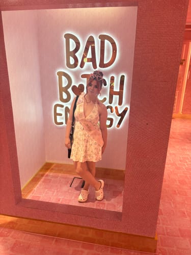Customer posing in front of a bright pink neon sign during an 18th birthday celebration at the Walk Ins venue.