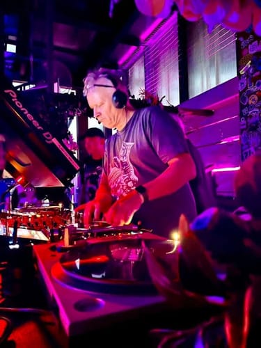 Customer's Term Limits t-shirt worn by a DJ at a concert with purple lighting.