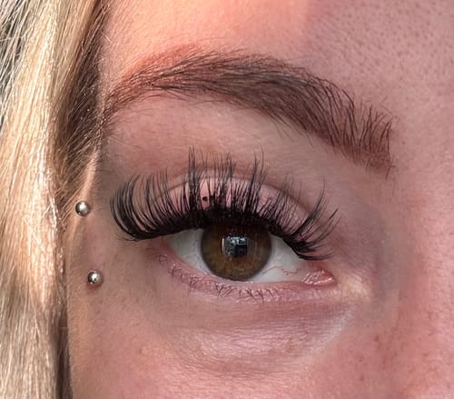 Reviewer's Auge mit Heart To Break Wimpernextensions, die einen dramatischen und vollen Look zeigen