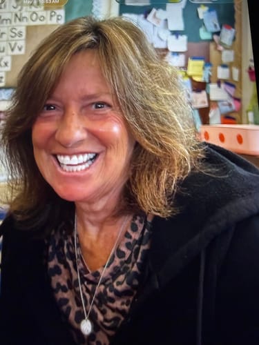 Customer's smiling person wearing a dark top, with Koriderm cream appearing to provide a glowing, healthy complexion.