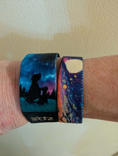 Reviewer's wrist wearing the Love You To The Moon bracelet with a design of two animal silhouettes under a starry sky.