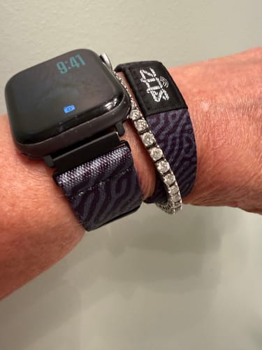 Close-up of a customer wearing the patterned Watchband+ Adapter on their watch, next to a matching bracelet.