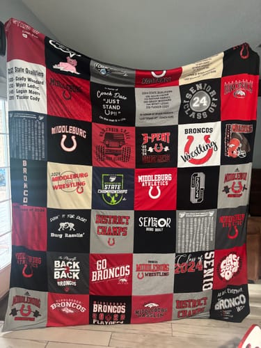 Reviewer's large Project Repat T-Shirt Quilt made of red, black, and grey sports and school-themed shirts.