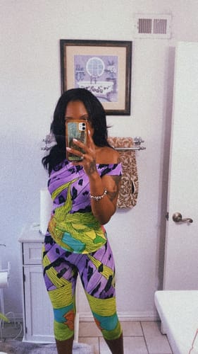 Reviewer's mirror selfie in a bathroom showing the fit of the Naked Print Capri Legging and matching top.