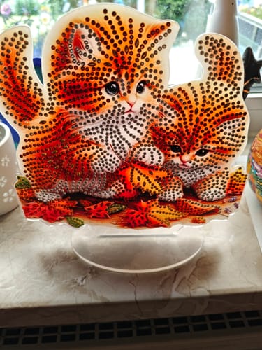 Fertiges Diamond Painting Ornament eines Kunden, das zwei orangefarbene Kätzchen auf einem Ständer zeigt.
