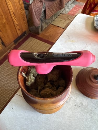 Customer's Blueberry Syrup Indica flower stored in a wooden bowl with a pink glass pipe resting on top.