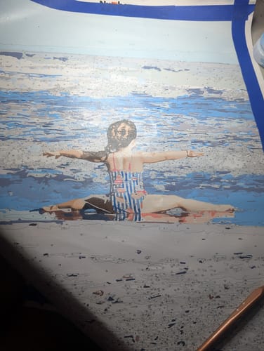 Customer's Custom Paint by Numbers Kit painting in progress, showing a person doing a split by the blue ocean.