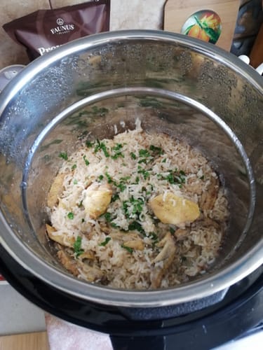 Customer's Novio SteelCook multicooker containing freshly prepared chicken and rice seasoned with fresh herbs.