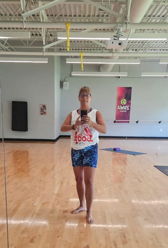 Customer's white Eagle Boop Comfort Colors Tank Top worn by a person in a gym mirror selfie.
