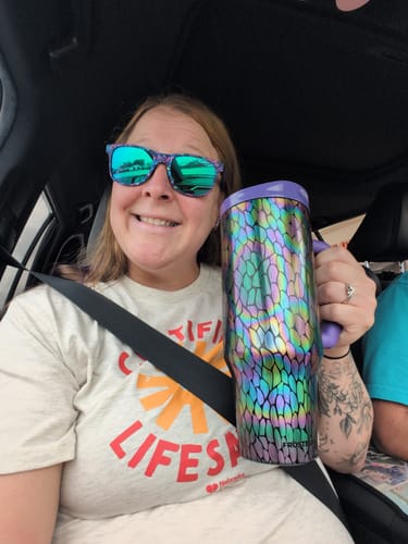 Reviewer's metallic Thicc Buddy 40oz mug with a colorful pattern held in a car.