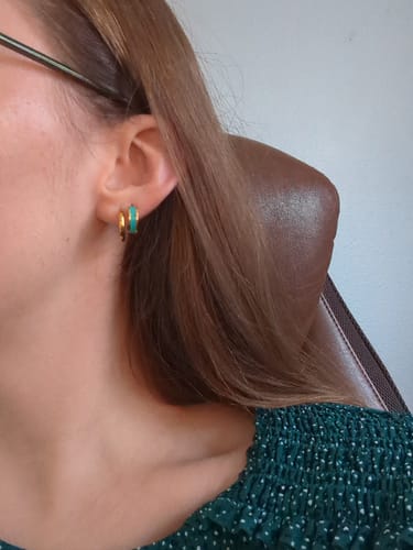 Reviewer's ear wearing a gold and teal Leigh Teal Hoop Earring