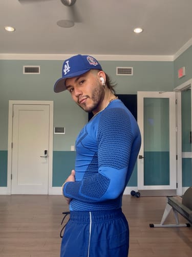 Customer's side profile wearing the blue Superman Compression Longsleeves, showing sculpted paneling.