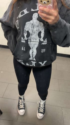 Customer's oversized black Gold's Gym Classic Pullover hoodie with a distressed graphic, worn with leggings.