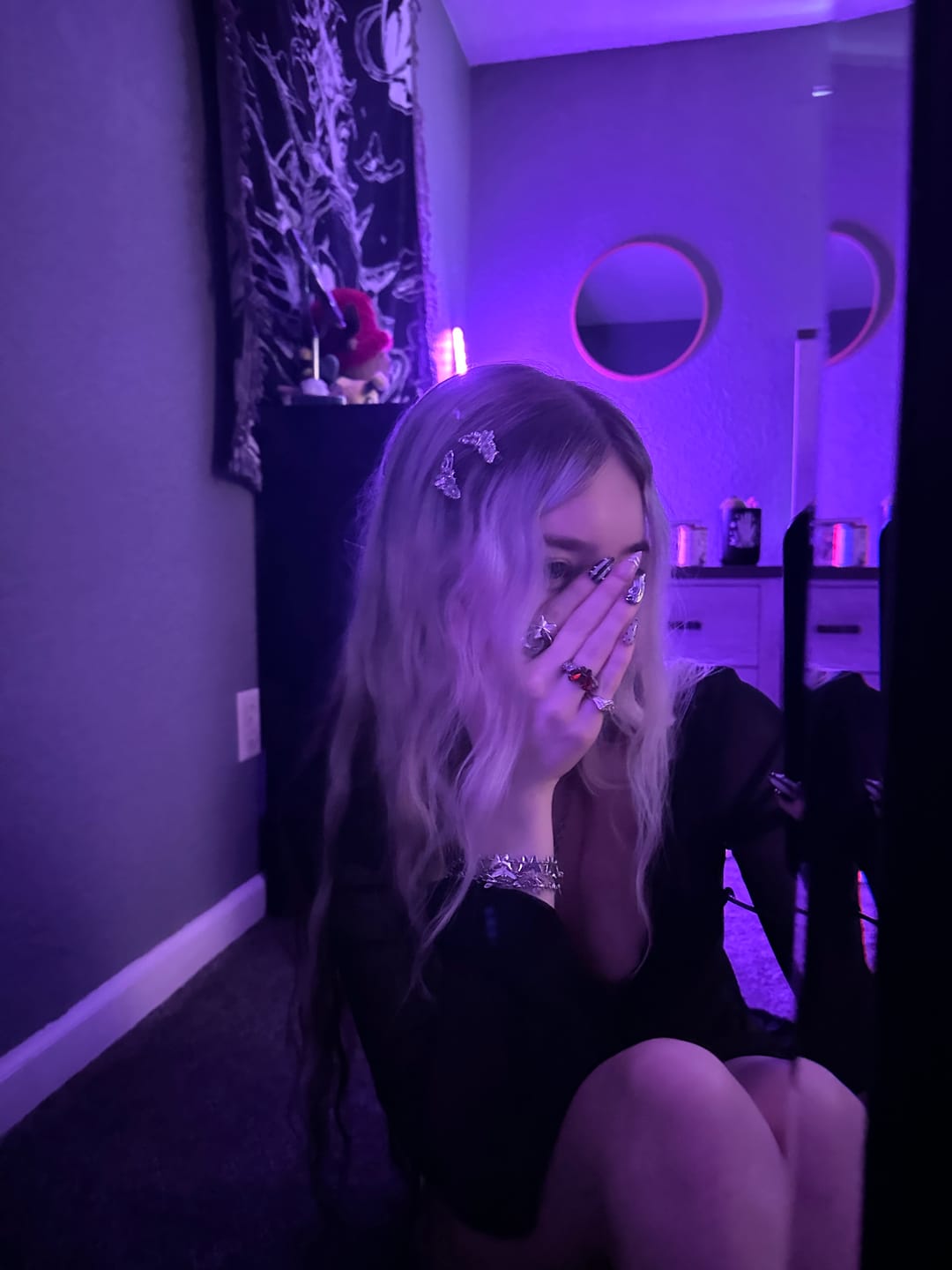 Customer wearing silver hair clips and jewelry in purple lighting