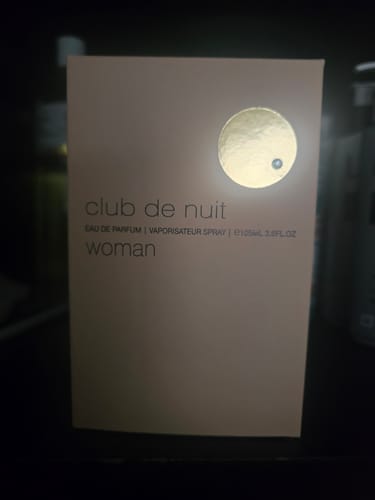 Customer's perfume box for Armaf Club de Nuit Woman, showing the beige packaging with a gold circular accent.