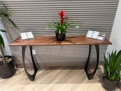Customer's matte black Custom 204 Cleo table legs supporting a wooden console table in a living space.