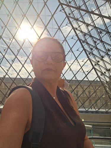 Customer's Iracema sunglasses worn while standing in front of a glass geometric structure.