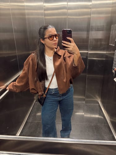Customer's mirror selfie wearing stylish Óculos de Sol Iracema with brownish lenses in an elevator.