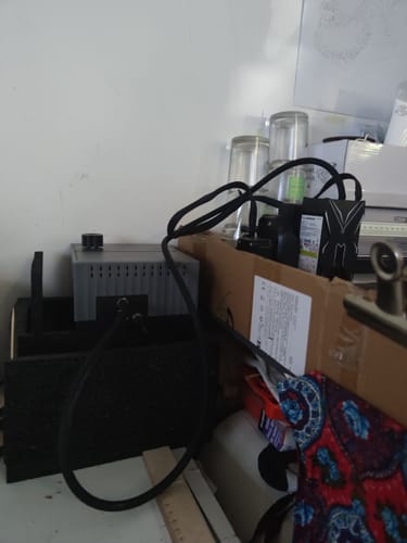 Customer's AtomStack F40 Air Assist unit sitting on a cluttered surface with connected black tubing.