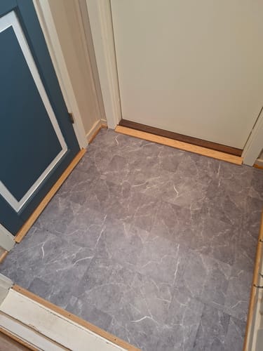 Customer's Verona marmor selvklebende fliser installert på et gulv, med grått marmormønster og hvite årer.