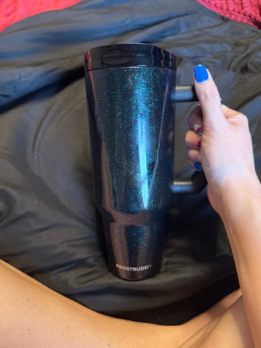 Customer holding their sparkly Mermaid Thicc Buddy 40oz mug by the handle.