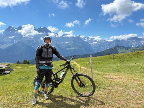 Reviewer wearing black Spectre Trail Shorts with a mountain bike on a scenic trail.