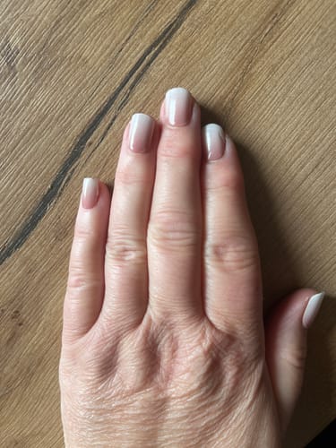 Hand einer Kundin, die ihre fertige Ombré-Maniküre zeigt, die sie mit dem Colour Flash Set gemacht hat.