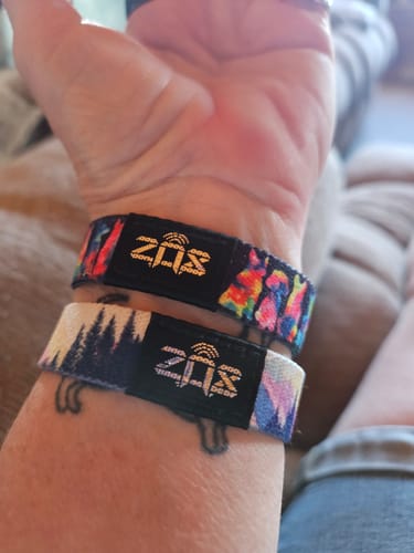 Close-up of a customer wearing two different, patterned Love Stays Bracelets on their wrist.