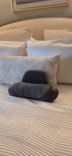 RESTORE neck pillow placed on a bed