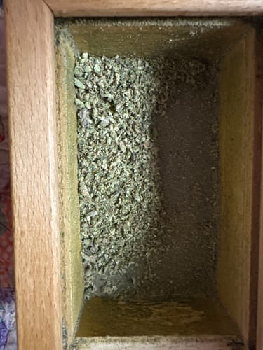 Customer's Roll Ready Ground flower in a wooden pollen box, showing the collected kief.