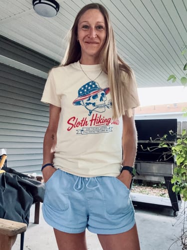 Reviewer standing on a patio while wearing the cream-colored, graphic Skull 250 T-Shirt.