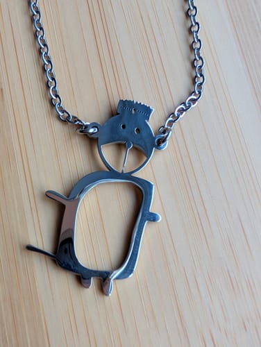 Nahaufnahme des filigranen Anhängers an einer silbernen Kette, der nach einer Kinderzeichnung angefertigt wurde.