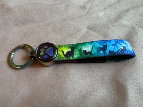 Customer's Until We Meet Again Cat Bracelet with black cat silhouettes on a colorful blue and green strap.