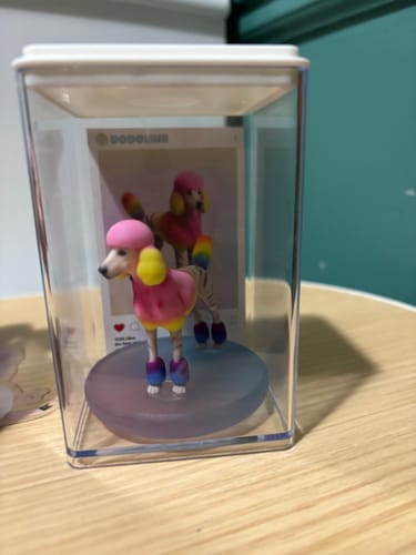 Customer's colorful Custom 3D Action Figure of their poodle in a clear display case.