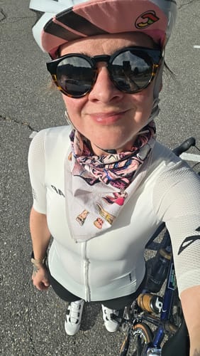 Reviewer wearing the Teeth Bandana as a neckerchief with a white cycling jersey and helmet.