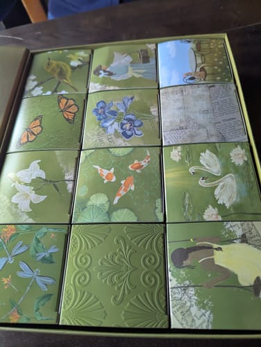 Reviewer's open Spring Box Packaging, revealing 12 smaller, decorative boxes with varied nature-themed illustrations.