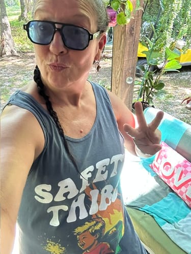 Reviewer wearing the grey Safety Third Comfort Colors Tank Top outdoors while holding up three fingers.