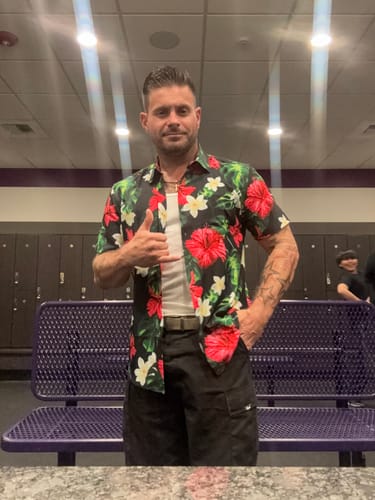 Reviewer wearing the Aloha Collection shirt in the black Hibiscus print, open over a white tank top.