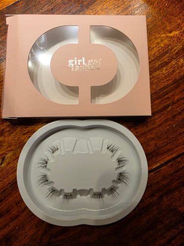 Ein Rezensent zeigt die Wimpern der Natural Edition Nr. 4 in der weißen Schale, neben der rosa Verpackung.