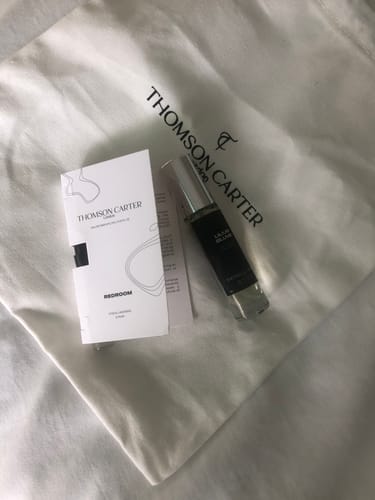 Customer's Lilium Blume Eau de Parfum sample bottle on a branded cloth bag next to another fragrance sample card.